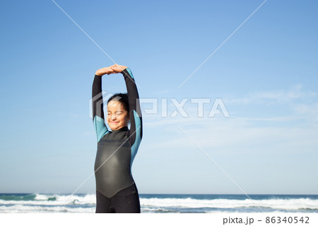 Sporty little girl exercising on beach 86340542