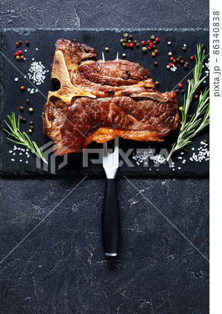 porterhouse steak is speared with carving fork 86340838