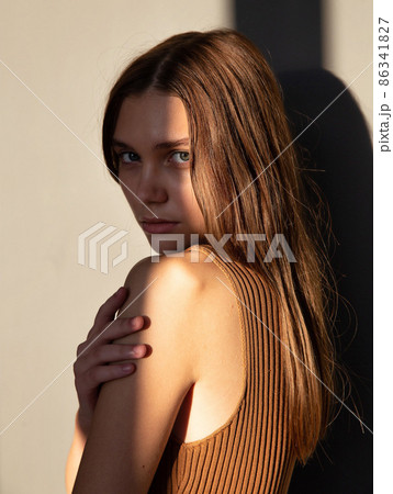 Woman with dark hair on beige Woman with dark hair on beige 86341827