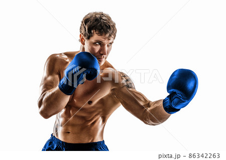 Portrait of muscular boxer who training and practicing uppercut in blue gloves on white background. 86342263