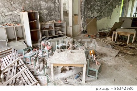 Children's toys covered with dust and debris in the ruins of an abandoned house.  86342930