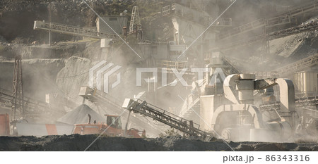 Stone crushing and screening machinery in clouds of dust at gravel quarry Stone crushing and screening machinery in clouds of dust at gravel quarry 86343316