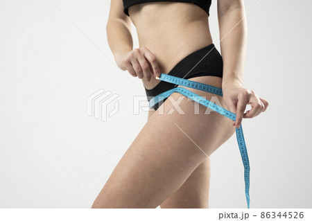 The girl taking measurements of her body on white background. The girl taking measurements of her body on white background. 86344526