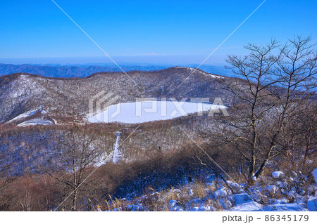 冬の群馬県赤城山の地蔵岳の地蔵岳の山頂付近から南東側の長七郎山と氷結した小沼の眺望 86345179
