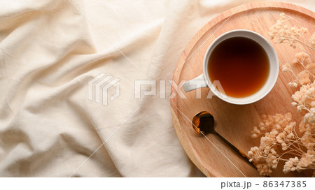 Cozy minimal tea table with dried flowers and teacup on wooden tray Cozy minimal tea table with dried flowers and teacup on wooden tray 86347385