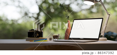 Modern office desk with nature view in the background and laptop mockup Modern office desk with nature view in the background and laptop mockup 86347392