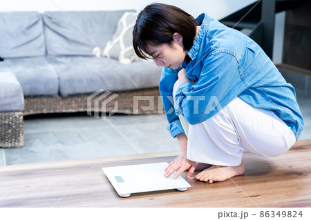 体重を計ってショックを受ける若い女性 体重を計ってショックを受ける若い女性 86349824
