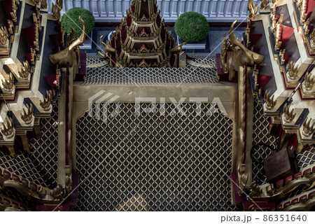 Symmetry view of Loha Prasart Metal Palace at Ratchanaddaram temple beyond the golden temple roof. Symmetry view of Loha Prasart Metal Palace at Ratchanaddaram temple beyond the golden temple roof. 86351640