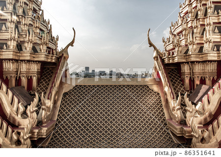 Symmetry view of Loha Prasart Metal Palace at Ratchanaddaram temple beyond the golden temple roof. Symmetry view of Loha Prasart Metal Palace at Ratchanaddaram temple beyond the golden temple roof. 86351641