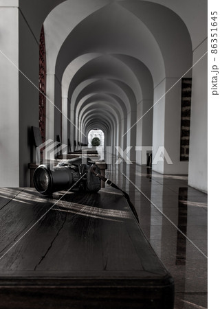 Natural light passing through the wall to the camera placed on a wooden table within Loha Prasart Metal Palace at Ratchanaddaram temple.. Natural light passing through the wall to the camera placed on a wooden table within Loha Prasart Metal Palace at Ratchanaddaram temple.. 86351645