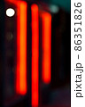 Defocused blurred neon orange light banner outside shop in the evening 86351826