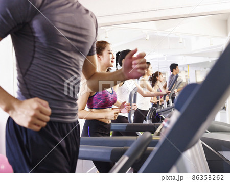 young asian adult working out on treadmill, focus on the girl in the middle 86353262