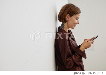 Tattooed Woman using Smartphone in Office Minimal Tattooed Woman using Smartphone in Office Minimal 86353934