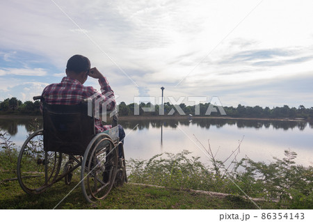 Young disabled man with blue sky background Young disabled man with blue sky background 86354143