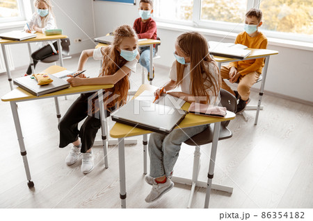 Busy school kids with notebooks writing test together Busy school kids with notebooks writing test together 86354182