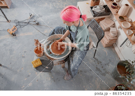 Woman crafter making clay dishes in pottery room Woman crafter making clay dishes in pottery room 86354235