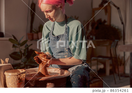 Potter working manually on pottery wheel in workroom Potter working manually on pottery wheel in workroom 86354261