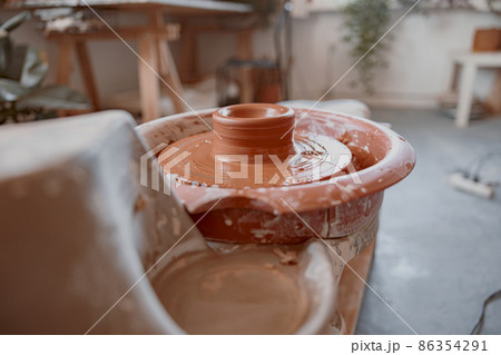 Raw clay product on potter wheel in workshop Raw clay product on potter wheel in workshop 86354291