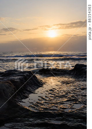 早朝の海岸で波に輝く太陽の光 早朝の海岸で波に輝く太陽の光 86354363
