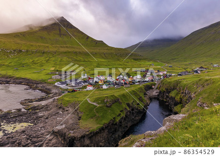 View of Gjogv village at misty sunset. Eysturoy, Faroe islands, Denmark 86354529