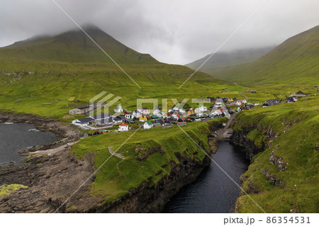 View of Gjogv village at misty sunset. Eysturoy, Faroe islands, Denmark 86354531