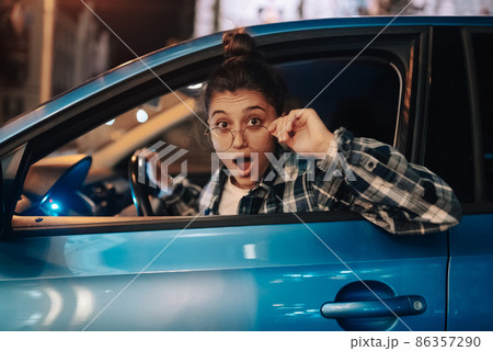 Woman driving car by night in the city 86357290