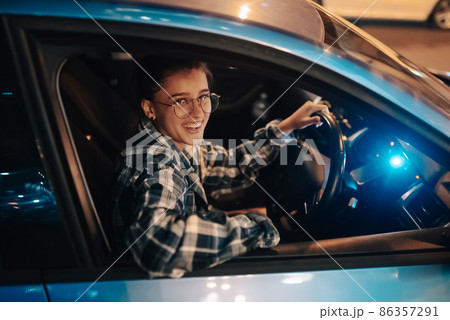 Woman driving car by night in the city 86357291