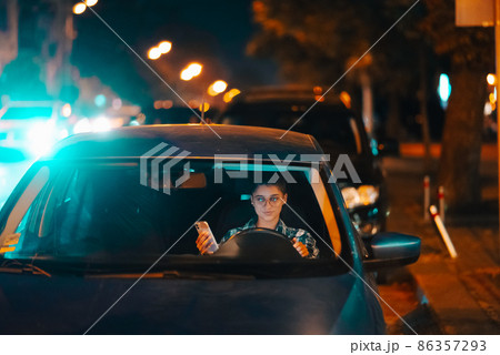 Lost female driver using mobile phone while driving at night. Lost female driver using mobile phone while driving at night. 86357293