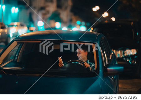 Lost female driver using mobile phone while driving at night. 86357295