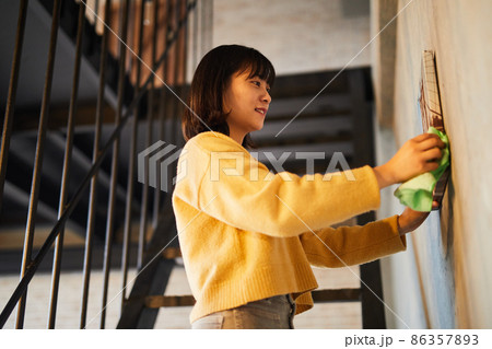 Young Woman Dusting Apartment 86357893