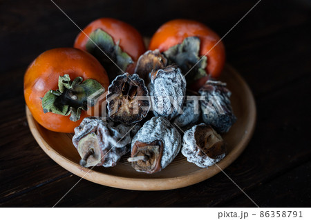 Dried persimmon and fresh persimmon on a wooden background. Healthy diet. Healthy diet 86358791