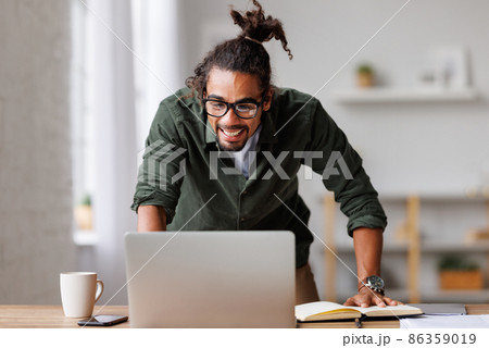 Overjoyed african american man looking at laptop screen feeling excited after receiving job offer 86359019