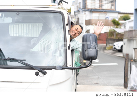 トラックを運転する作業服を着たミドル男性 86359111