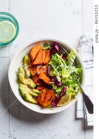 Baked sweet potato slices with avocado and green salad. Healthy vegan food concept. 86359255