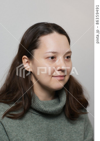 Closeup of a young woman's visage with piercing septum hanging from her nose. Closeup of a young woman's visage with piercing septum hanging from her nose. 86359491