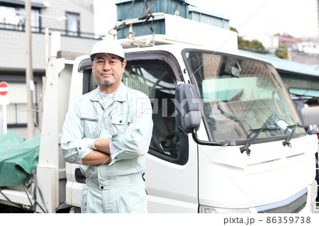トラックの前で腕組みをする作業服を着たミドル男性 トラックの前で腕組みをする作業服を着たミドル男性 86359738