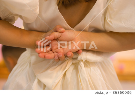 The girl behind her back holds a hand with crossed fingers. The girl behind her back holds a hand with crossed fingers. 86360036