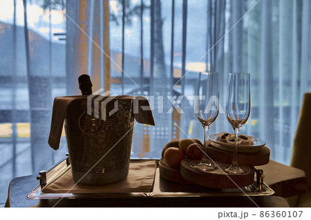 two vine glasses standing on black tray against window. 86360107