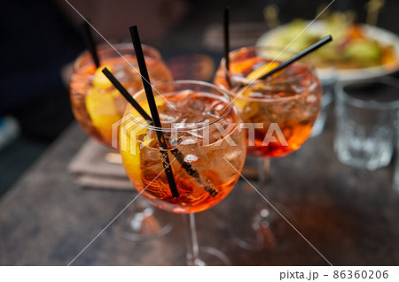 Italian cocktail with orange slices on gray stone table. Summer drink, homemade. 86360206