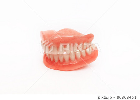 Full removable plastic denture of the jaws. Set of dentures on a white background. A side view of a dental prosthesis, isolate. Two acrylic dentures. Dentures or false teeth, close-up. Copy space 86363451