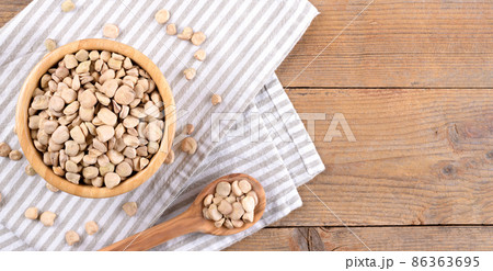 Cicerchia or indian pea in a bowl with napkin on natural wooden background, gluten free food. Cicerchia or indian pea in a bowl with napkin on natural wooden background, gluten free food. 86363695