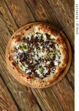 Delicious homemade pizza with mozzarella, mushrooms, beef and chicken. Wooden background, selective focus. Delicious homemade pizza with mozzarella, mushrooms, beef and chicken. Wooden background, selective focus. 86364145