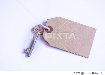 Key and brown paper tag on white background. Flat lay 86366264
