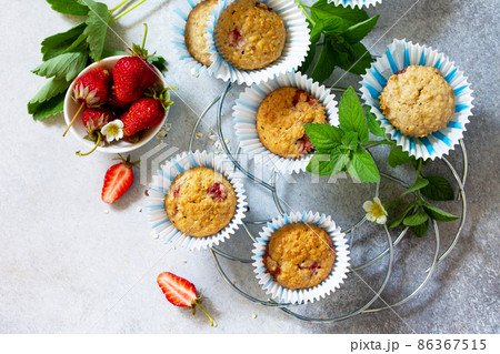 Summer dessert. Muffins with oatmeal flour and Fresh Strawberry on stone or concrete table. Flat lay. Top view. Copy space. Summer dessert. Muffins with oatmeal flour and Fresh Strawberry on stone or concrete table. Flat lay. Top view. Copy space. 86367515