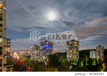 Night cityscape with full moon in clouds 86368367