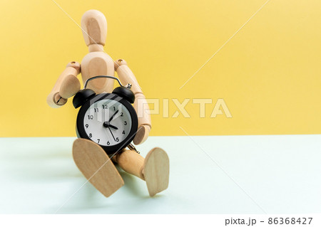 Wooden man alarm clock. The concept of transience of life. Lost time concept. with space for text Wooden man alarm clock. The concept of transience of life. Lost time concept. with space for text 86368427