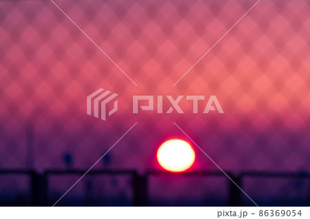 Blurred magenta and purple colored sunset through metal bars 86369054