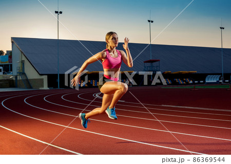 Runner sprinting towards success on run path running athletic track. Goal achievement concept. Runner sprinting towards success on run path running athletic track. Goal achievement concept. 86369544