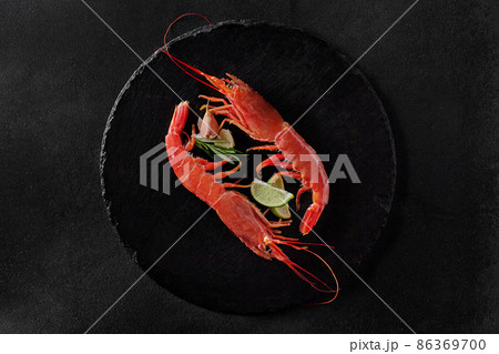 Top view of two shrimps with condiments on round slate board 86369700