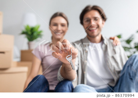 Glad happy young european husband in glasses and wife shows key from new own apartment in room interior 86370994